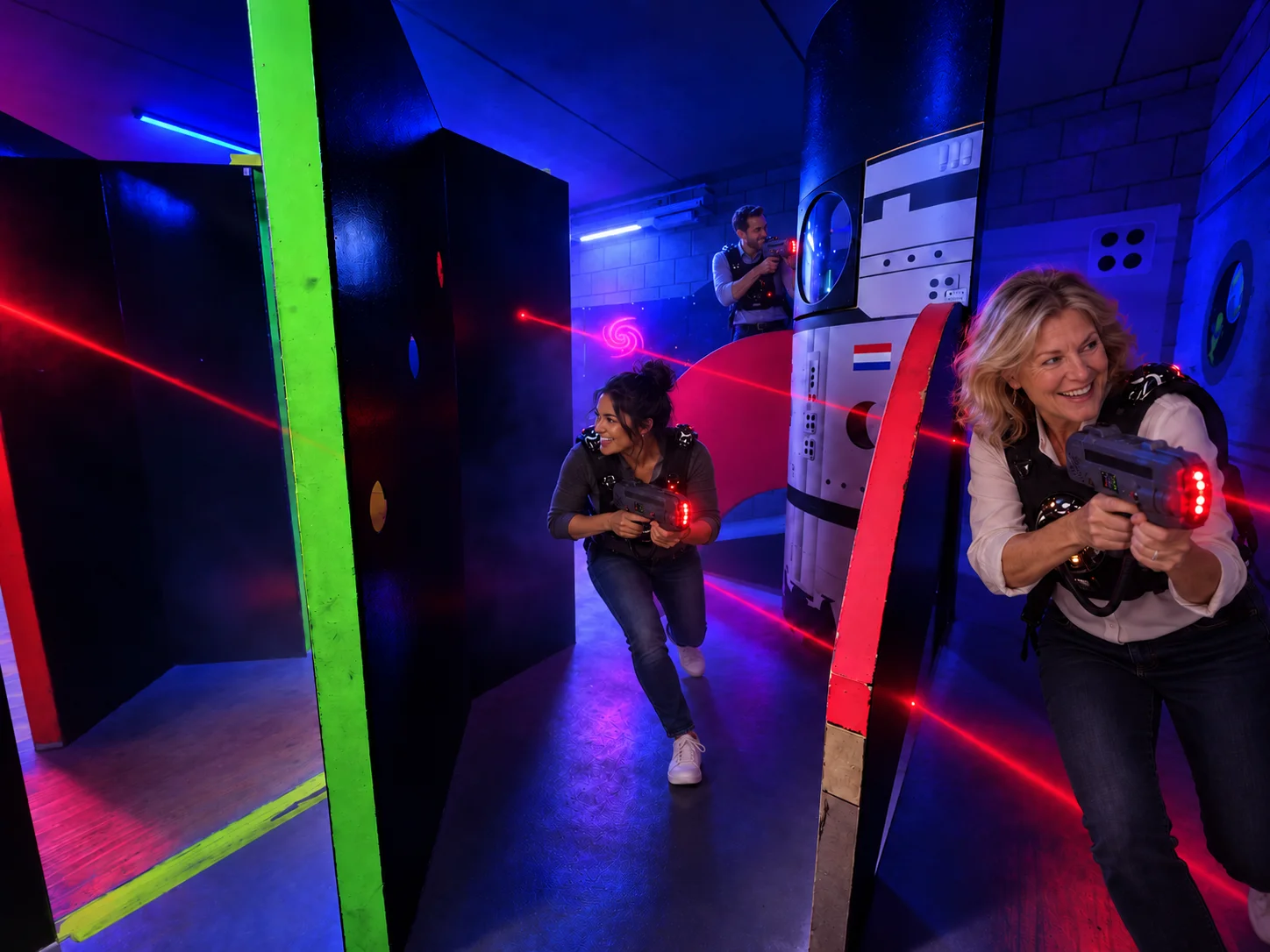 Drie collega’s lasergamen in de FunSpace-laserzone, één van hen staat hoger achter de raket